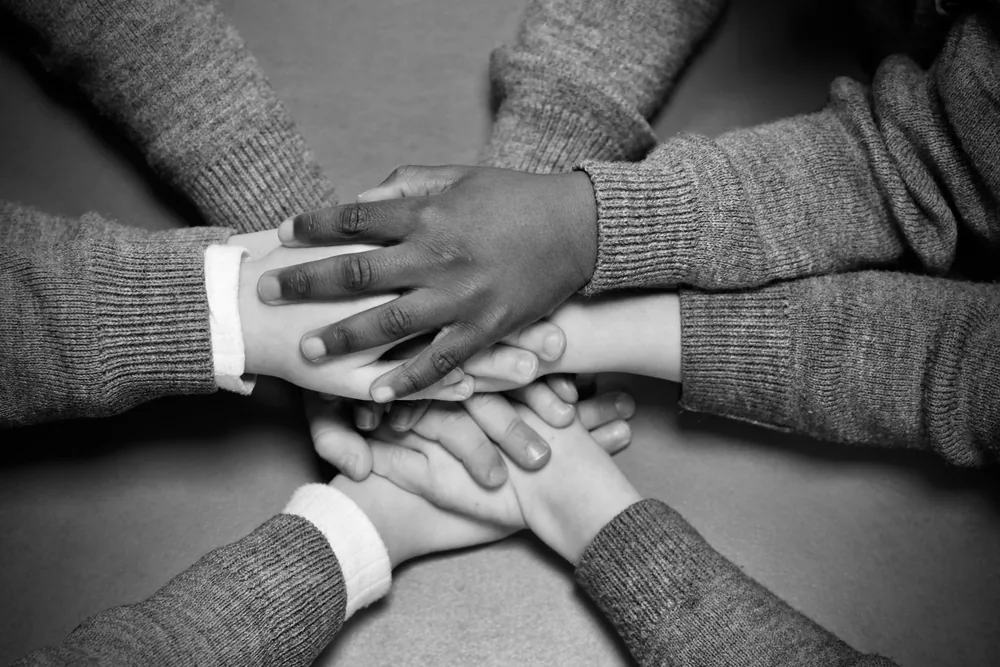 Young players stacking hands together